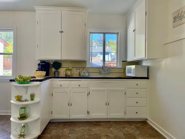 a kitchen with stainless steel appliances granite countertop white cabinets and a stove