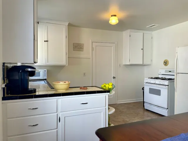 a white refrigerator freezer and a stove sitting inside of a kitchen