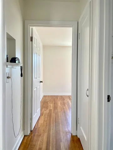 an empty room with wooden floor cabinet and windows