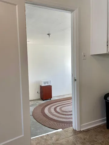 a view of a livingroom with wooden floor and a rug