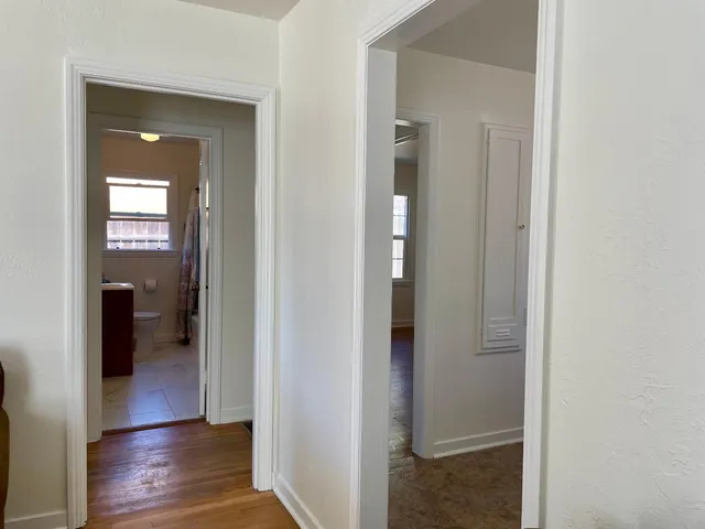 a view of a hallway with wooden floor and closet