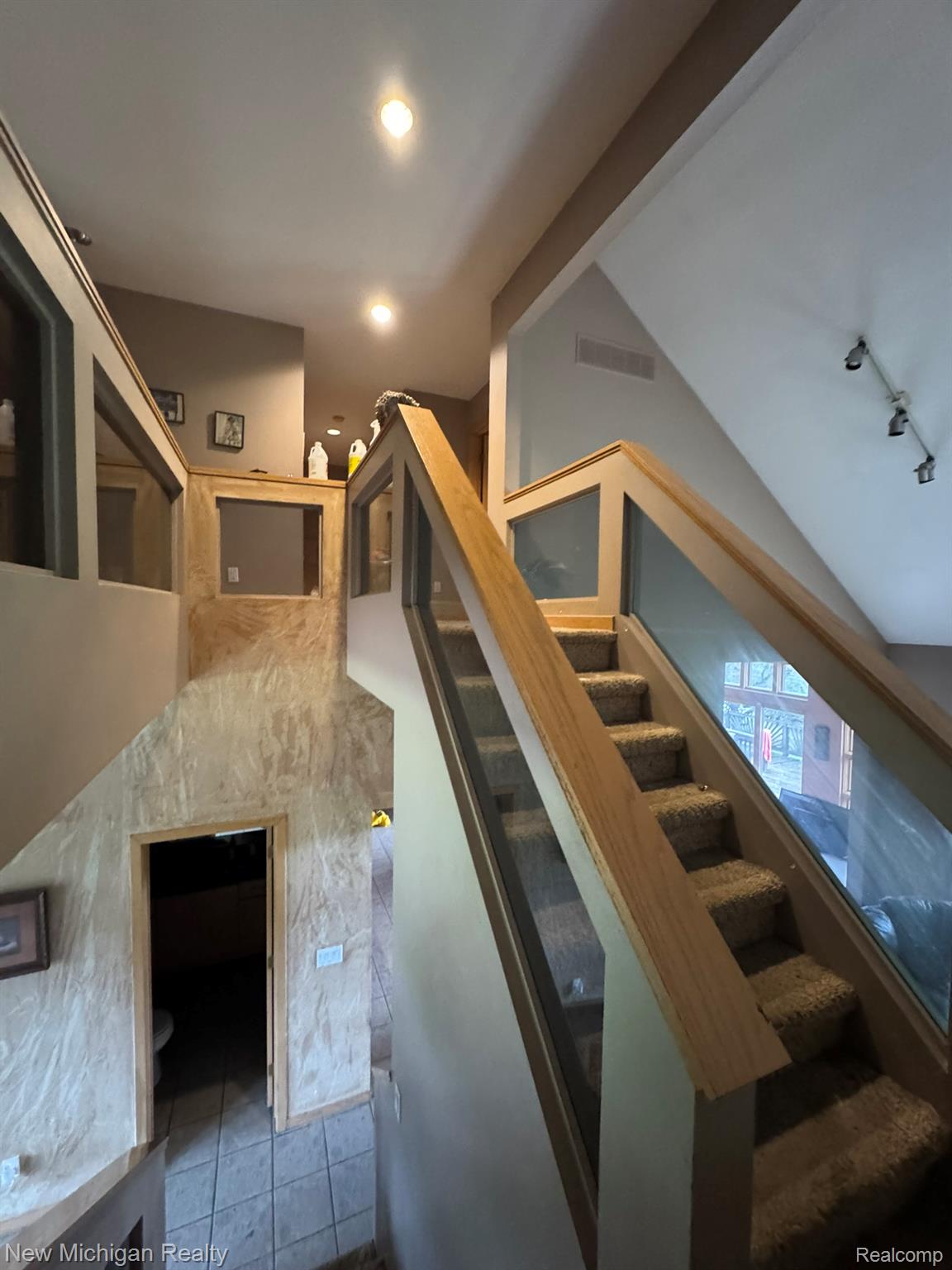 11082 Blaine Road Brighton, MI 48114 - Photo 29 of 34 Staircase featuring wood railings with glass panel inserts