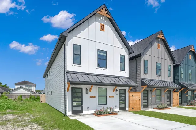a view of a white house with a yard and plants