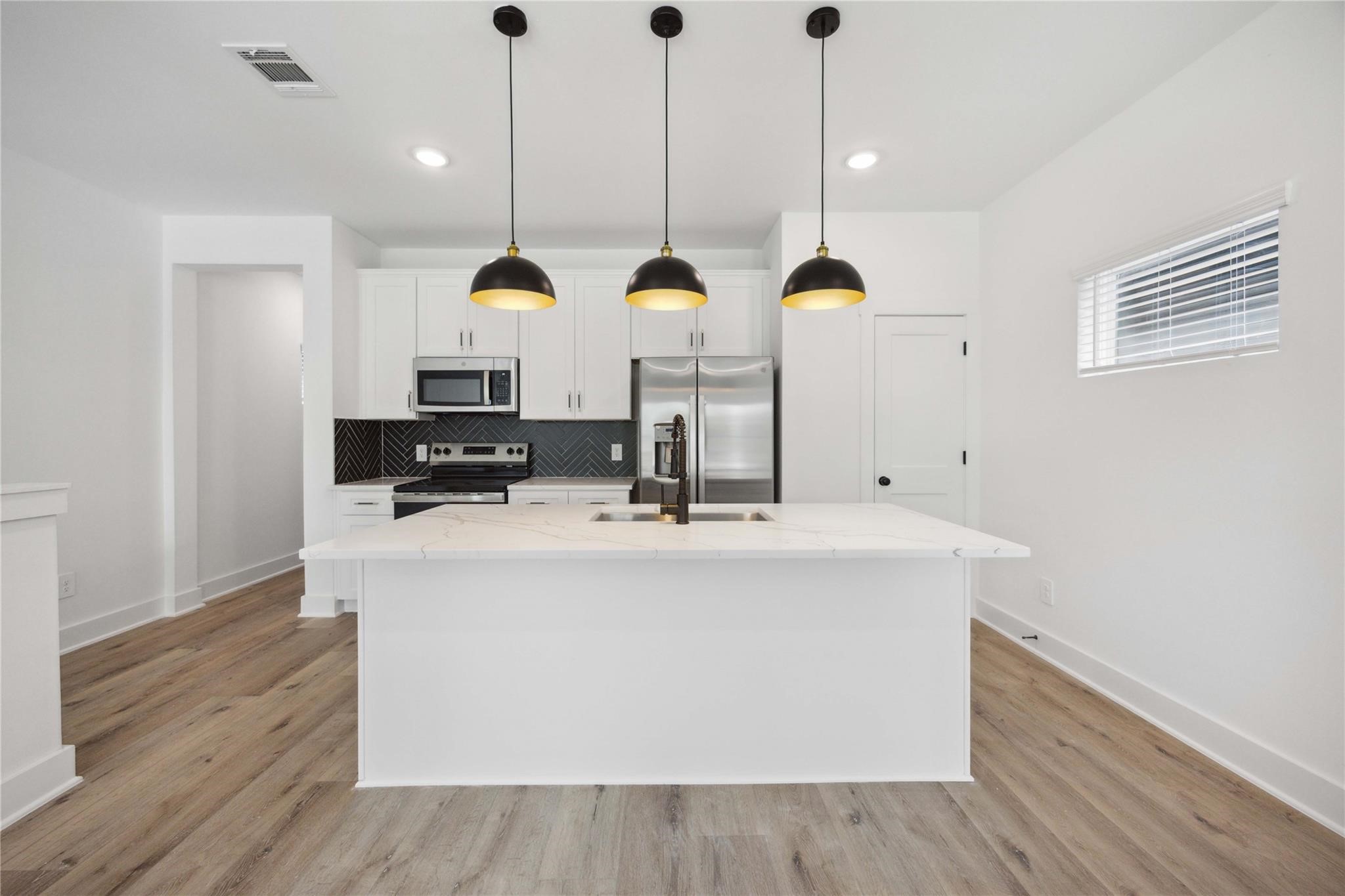 8017 A Cora Street Houston, TX 77088 - Photo 17 of 29 a kitchen with stainless steel appliances kitchen island granite countertop a sink a stove and a wooden floors