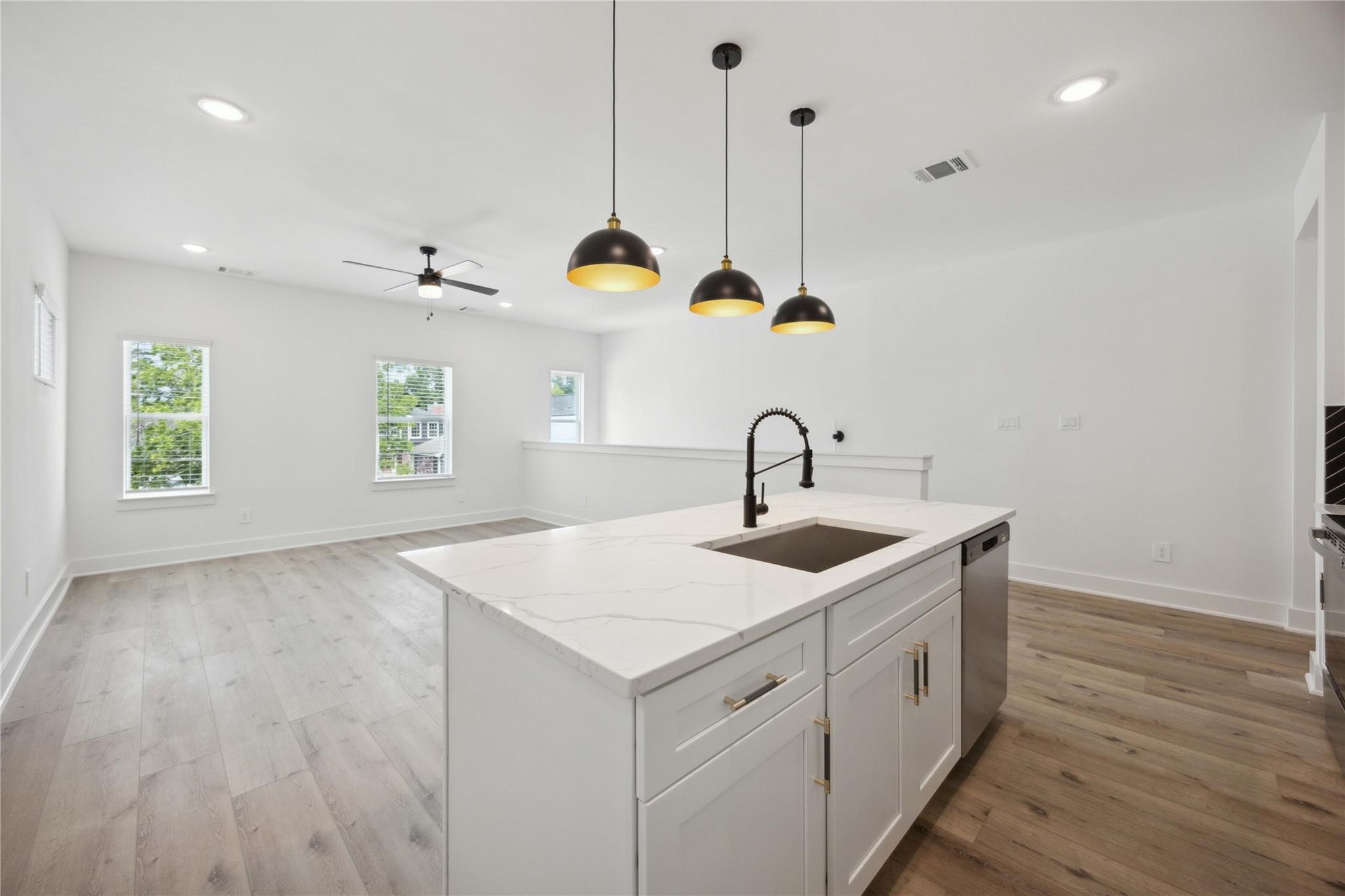 8017 A Cora Street Houston, TX 77088 - Photo 18 of 29 a kitchen with a sink a faucet a window and wooden floor