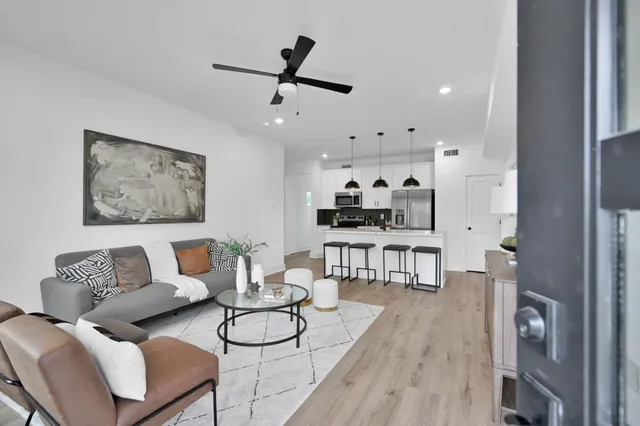 a living room with furniture and a wooden floor