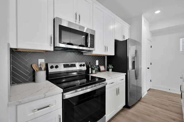 a kitchen with stainless steel appliances granite countertop a sink a counter space and cabinets