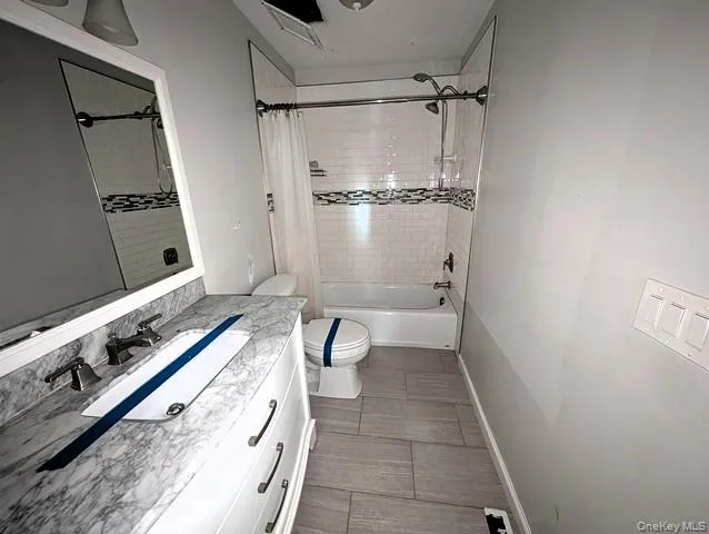 a bathroom with a granite countertop sink a toilet and shower