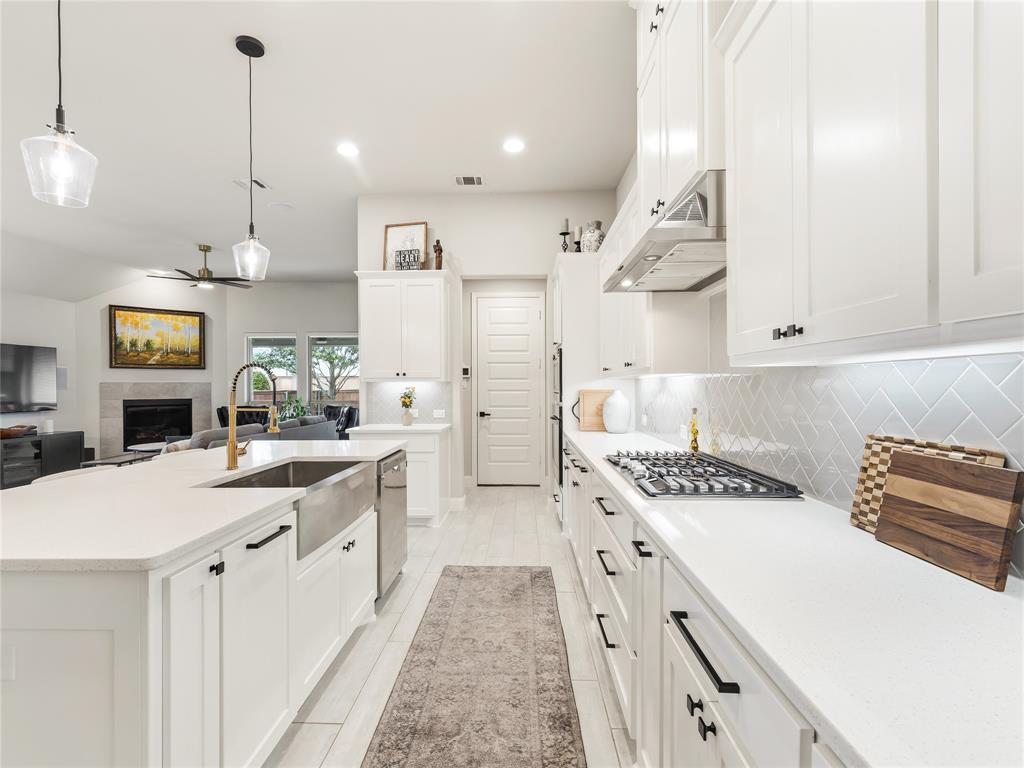 15340 Crape Myrtle Road Frisco, TX 75035 - Photo 13 of 40 Modern kitchen featuring white shaker cabinetry, stainless steel appliances, and light-toned countertops