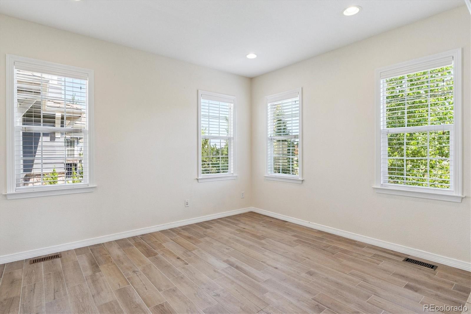 10426 Willowwisp Way Highlands Ranch, CO 80126 - Photo 17 of 47 a view of an empty room with wooden floor and windows