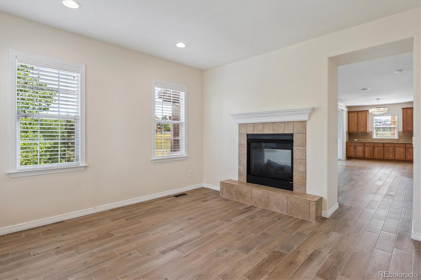 10426 Willowwisp Way Highlands Ranch, CO 80126 - Photo 18 of 47 an empty room with wooden floor fireplace and windows