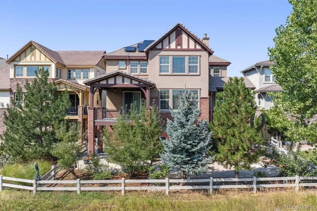 a front view of a house with a yard and potted plants