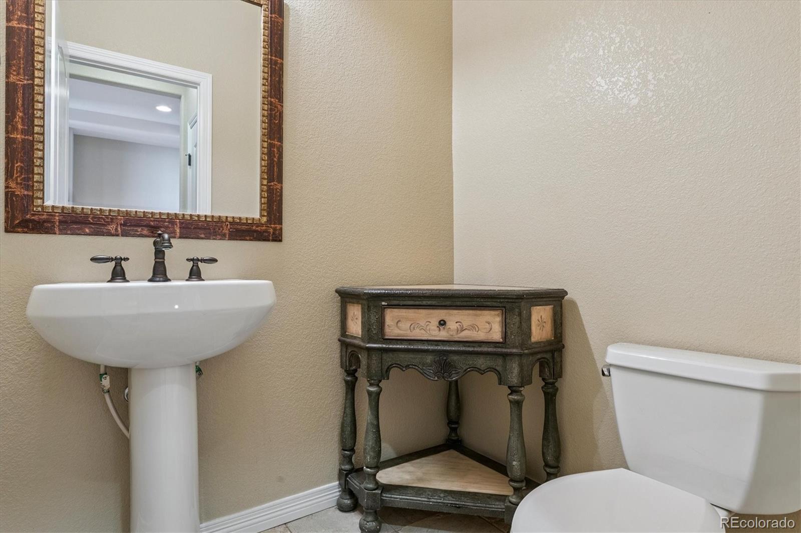 10426 Willowwisp Way Highlands Ranch, CO 80126 - Photo 5 of 47 a bathroom with a toilet sink and mirror