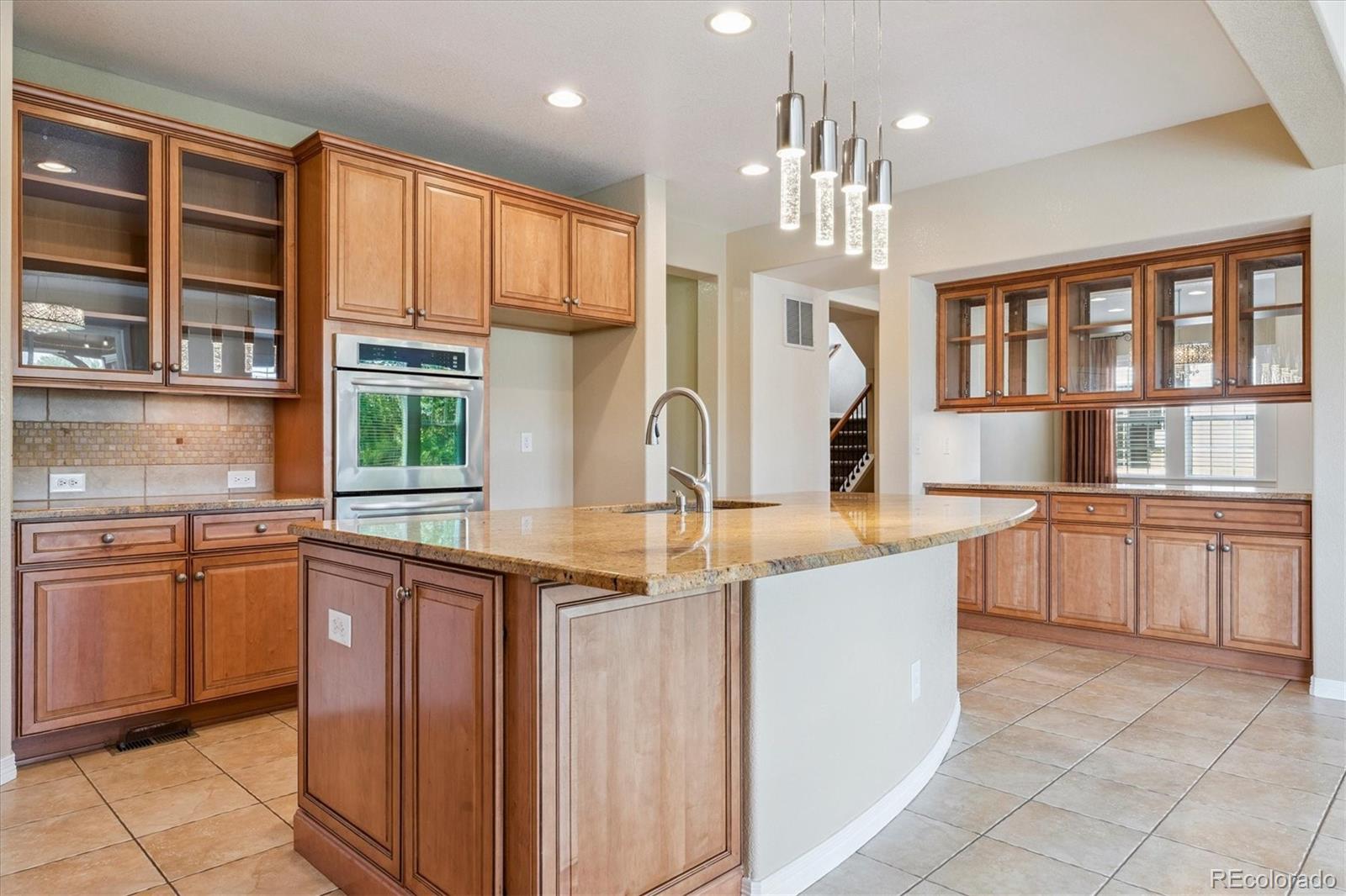 10426 Willowwisp Way Highlands Ranch, CO 80126 - Photo 9 of 47 a kitchen with kitchen island granite countertop a sink stove and cabinets