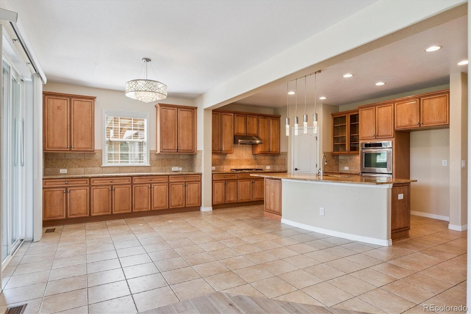 10426 Willowwisp Way Highlands Ranch, CO 80126 - Photo 10 of 47 a large kitchen with a large counter top stainless steel appliances and cabinets