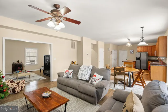 a kitchen with granite countertop a stove top oven a sink dishwasher a dining table and chairs with wooden floor