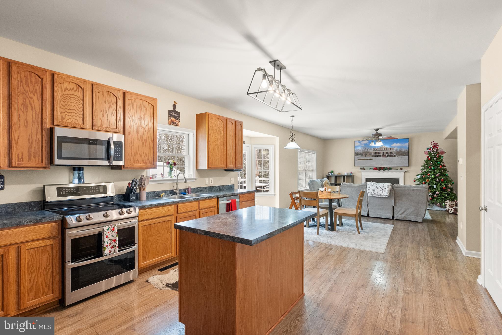 10757 Shenandoah Path Catlett, VA 20119 - Photo 25 of 55 a kitchen with granite countertop a stove top oven a sink dishwasher a dining table and chairs with wooden floor