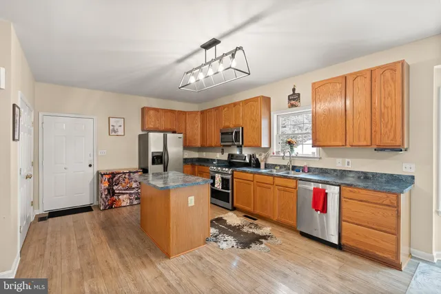 a kitchen with stainless steel appliances granite countertop a refrigerator and a sink
