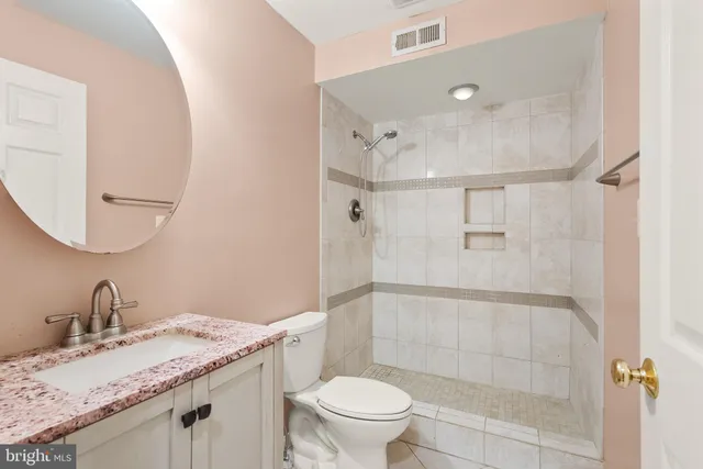 a bathroom with a granite countertop sink toilet and shower