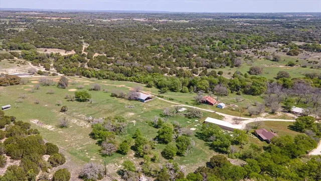 an aerial view of residential houses with outdoor space and trees