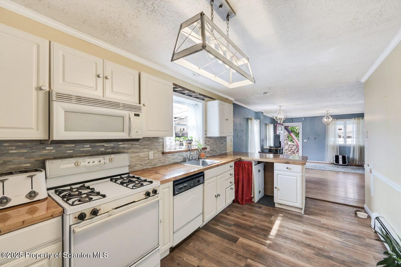 2035 Delaware Street Dunmore, PA 18512 - Photo 14 of 44 a kitchen with stainless steel appliances granite countertop a stove a sink dishwasher and white cabinets with wooden floor