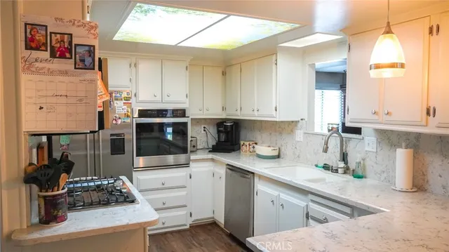 a kitchen with stainless steel appliances kitchen island granite countertop a sink and cabinets