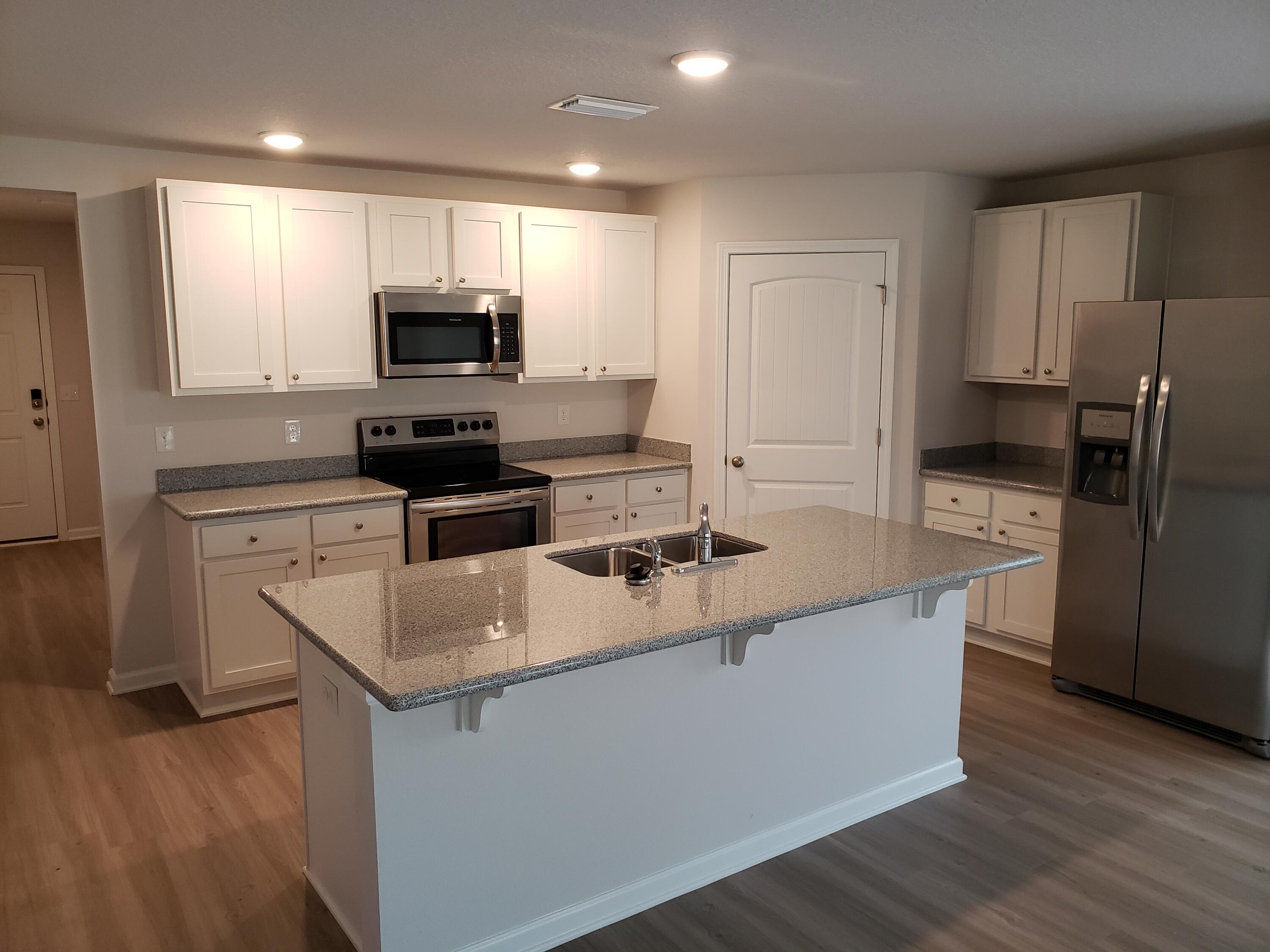 2875 Patriot Ridge Drive Crestview, FL 32539 - Photo 9 of 39 a kitchen with white cabinets stainless steel appliances and wooden floor