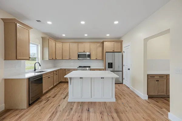 a kitchen with a sink a counter top space stainless steel appliances and cabinets