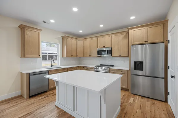 a kitchen with wooden cabinets and stainless steel appliances