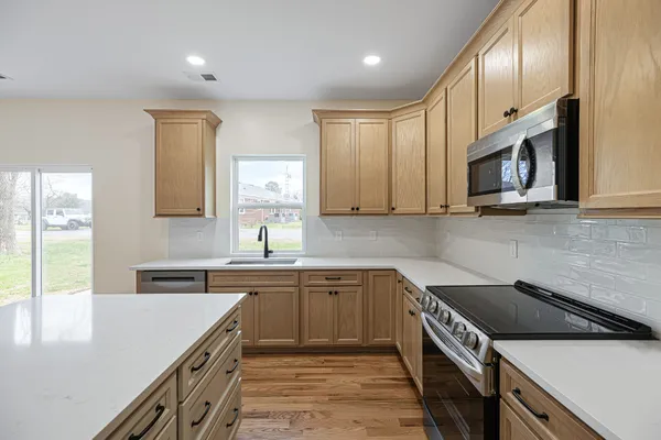a kitchen with a sink stove top oven and cabinets