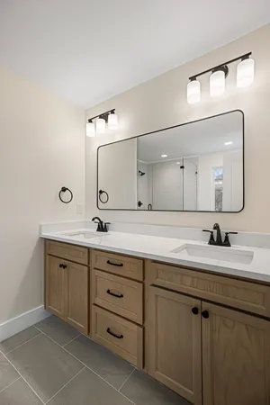 a bathroom with a double vanity sink and a mirror