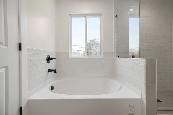 a white bath tub sitting in a bathroom next to a window