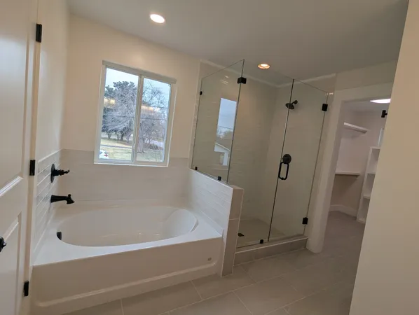 a white bath tub sitting next to a shower