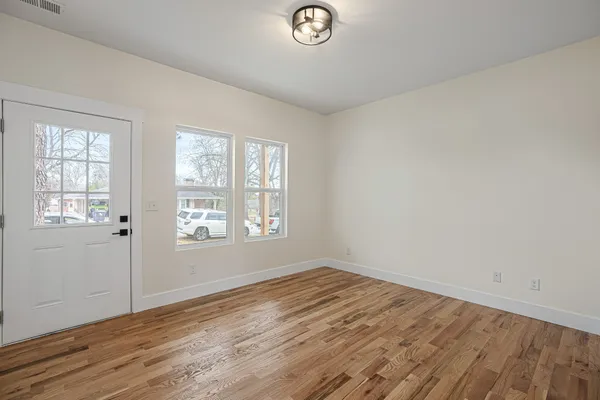 a view of empty room with wooden floor