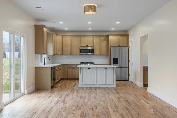 a kitchen with stainless steel appliances granite countertop a refrigerator sink and white cabinets