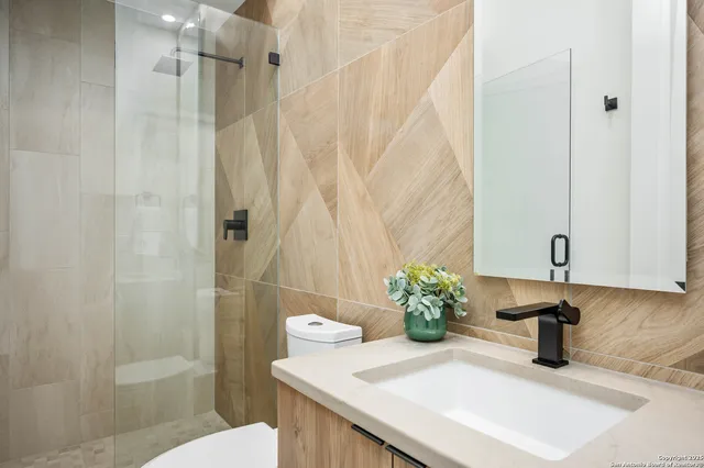 a bathroom with a sink a toilet and shower