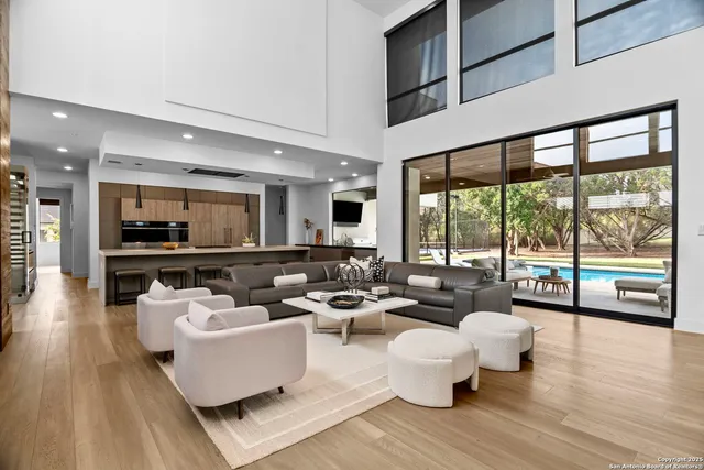a living room with furniture and a large window with wooden floor