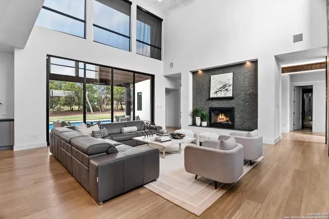 a living room with furniture wooden floor and a large window