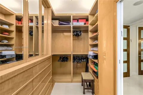 a view of walk in closet with clothes and shoes