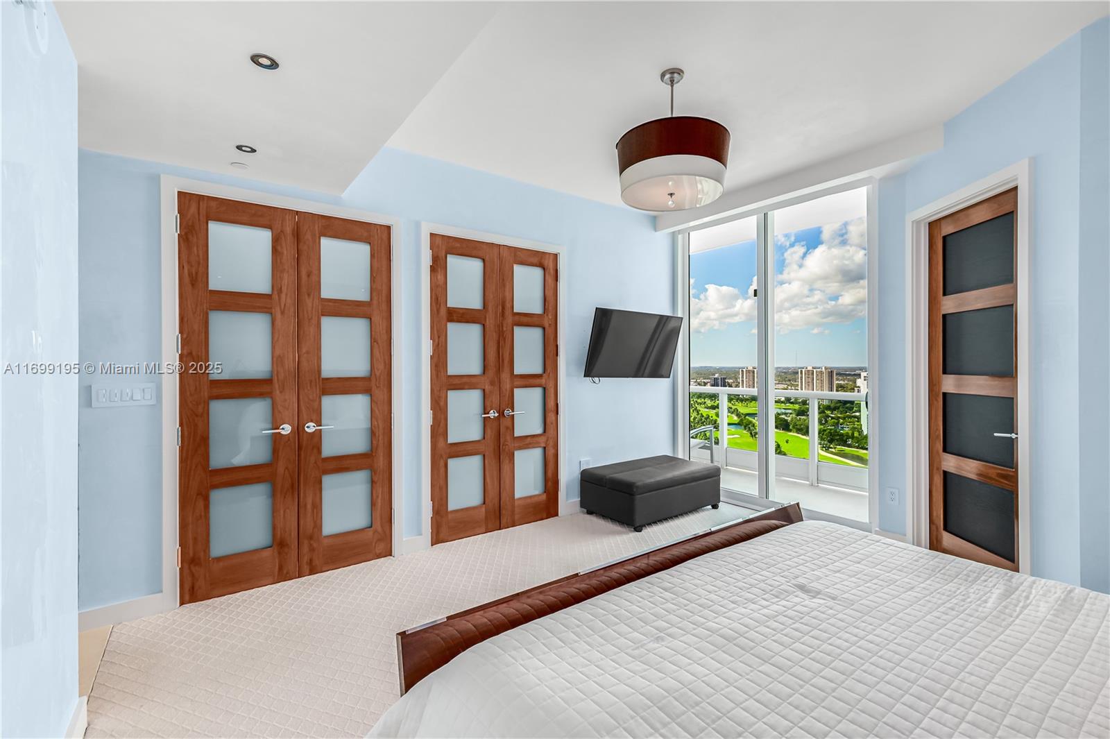 20155 Northeast 38th Court, Unit 2903 Aventura, FL 33180 - Photo 23 of 28 a bedroom with a bed and a large window