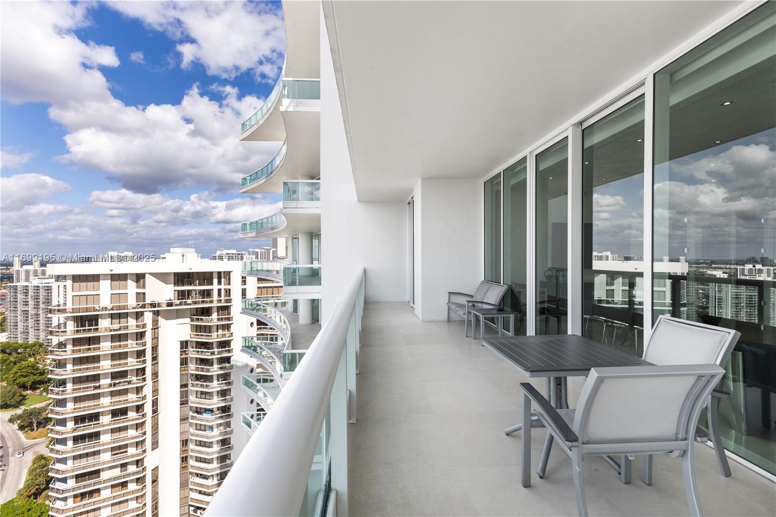 20155 Northeast 38th Court, Unit 2903 Aventura, FL 33180 - Photo 26 of 28 a view of a balcony with chairs