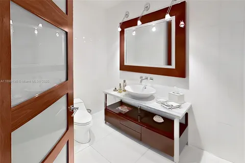 a bathroom with a sink mirror vanity and toilet