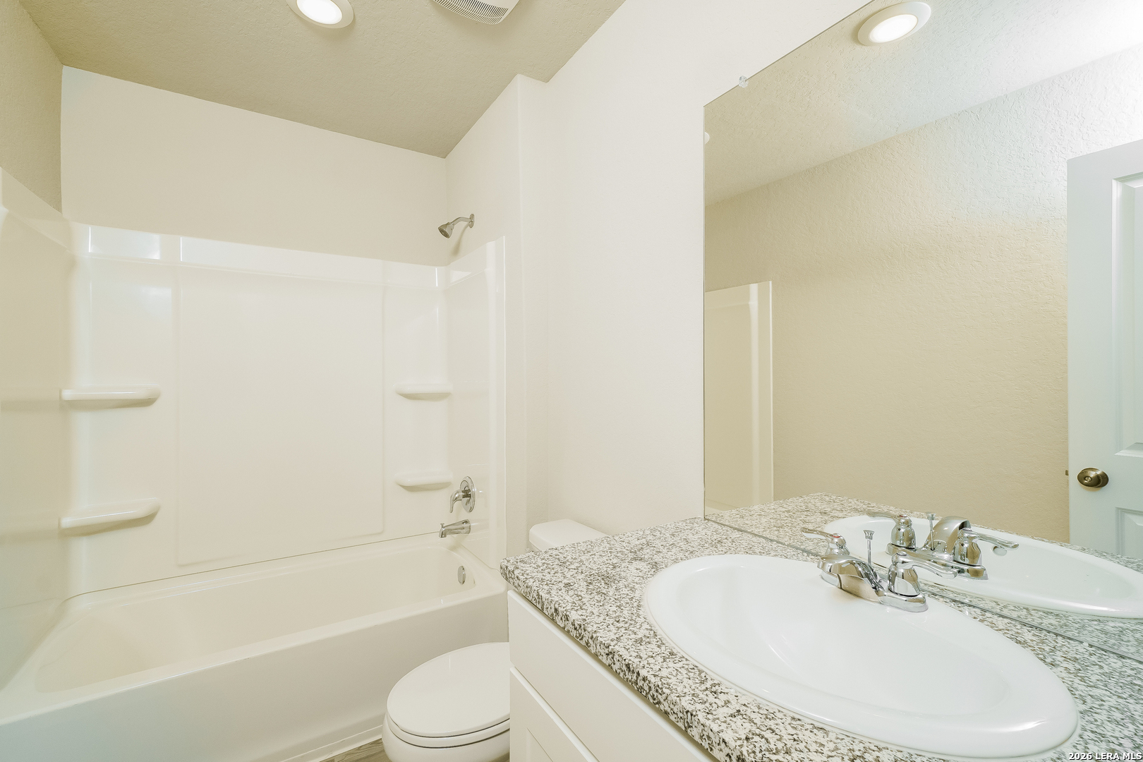 9115 Griffith Converse, TX 78109 - Photo 13 of 15 a bathroom with a granite countertop bathtub shower sink vanity mirror and toilet