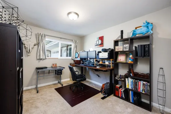 a view of a workspace with furniture and a window