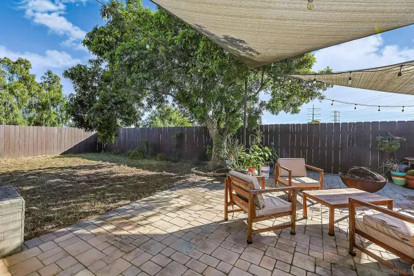 a backyard of a house with table and chairs