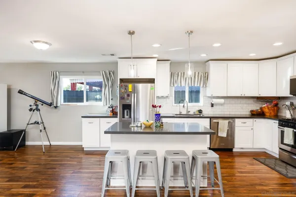 a kitchen with stainless steel appliances granite countertop a stove and a wooden floors