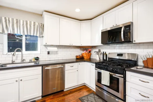 a kitchen with cabinets stainless steel appliances a sink and a counter space