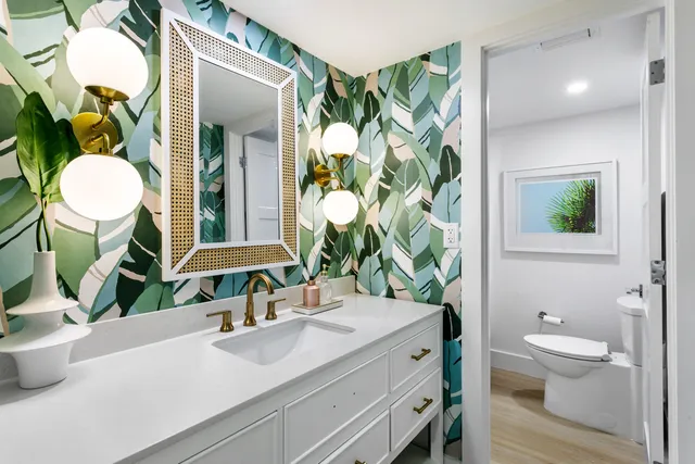a bathroom with a granite countertop sink mirror vanity and toilet