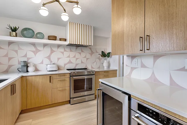 a kitchen with stainless steel appliances granite countertop a sink a stove and cabinets