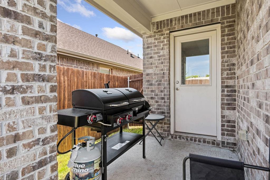 822 Ramble Road Lavon, TX 75166 - Photo 29 of 35 Covered patio with concrete flooring, brick exterior walls, and a privacy fence
